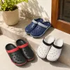 Three pairs of crocs in black, red, black, white, blue and white checkered fabric are on display details Picture